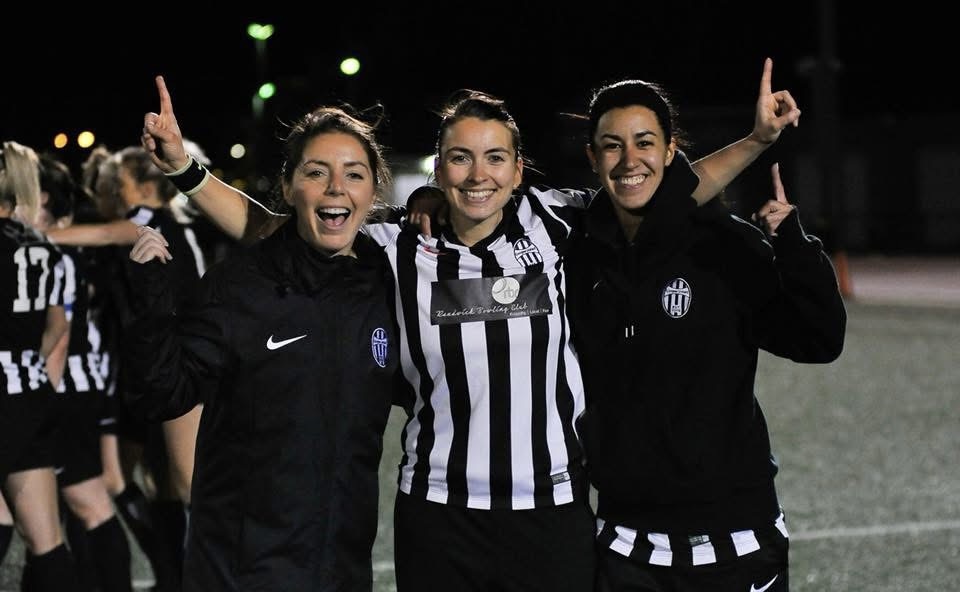 Rebecca and teammates celebrating a night match in black and white striped football kits