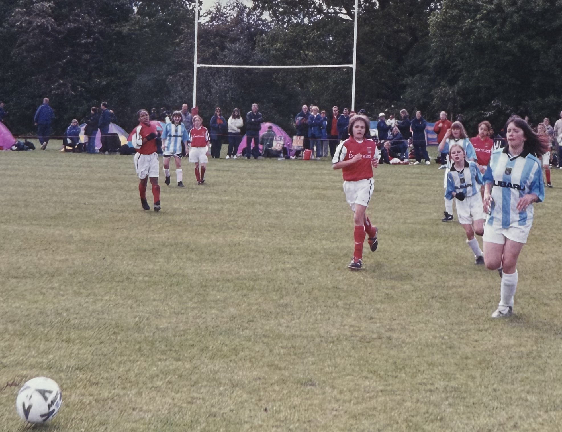 Young Rebecca playing in a youth football match on a grass pitch